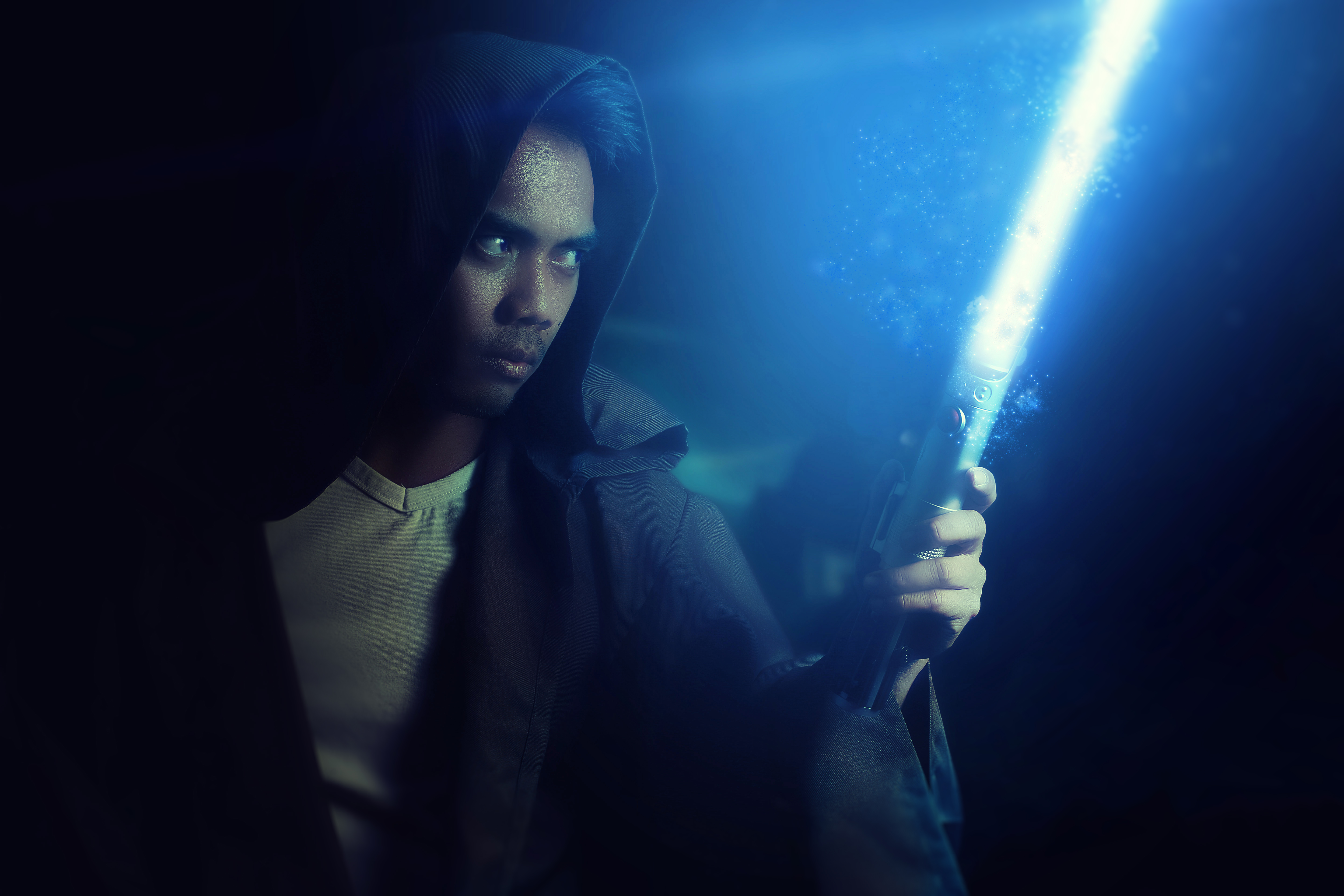 Young warrior holding a lightsaber on a dark background